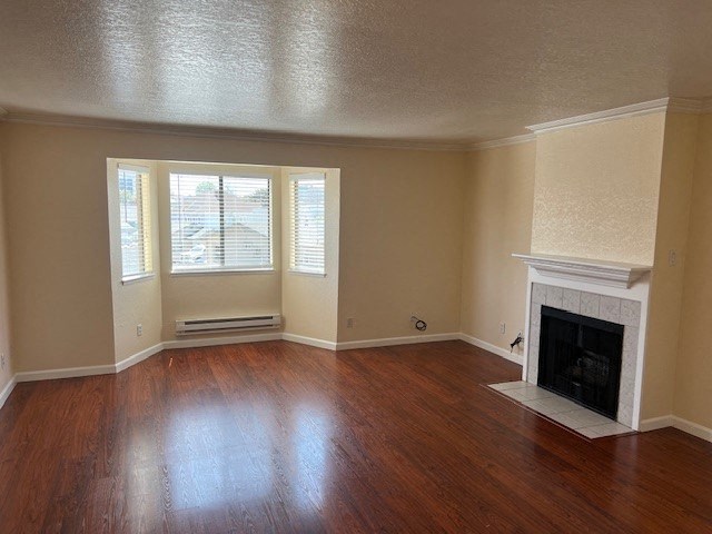 an empty living room with a fireplace and wooden floors