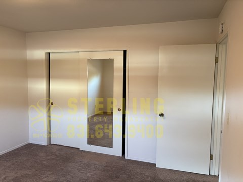 A room with a carpet floor and a glass door.