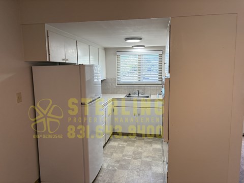 A kitchen area with a refrigerator and a sink.