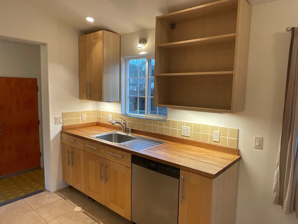 an empty kitchen with a sink and a window