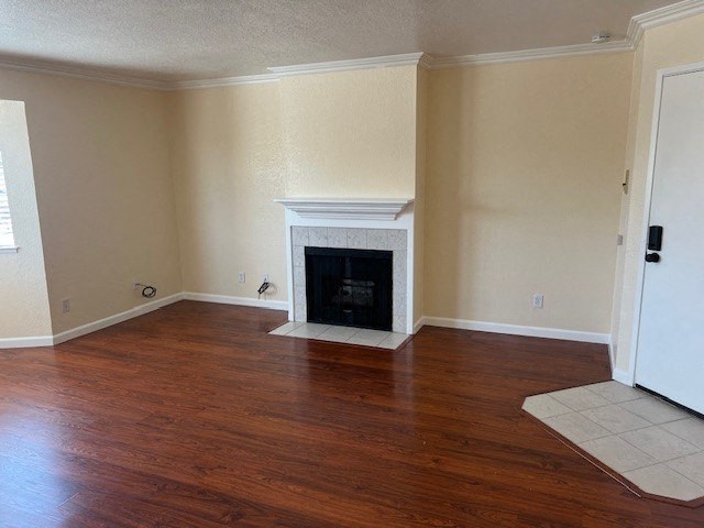 an empty living room with a fireplace and wooden floors