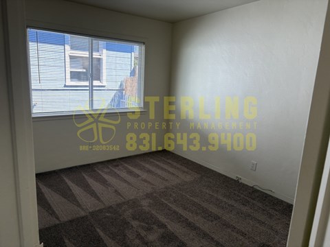 A room with a Sterling Property Management logo and contact number on the wall.