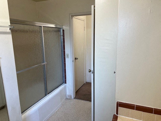 a bathroom with a shower with a glass door