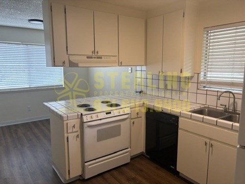 A kitchen with a stove, oven, and sink.