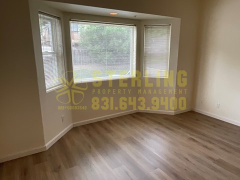 A room with a window and a Sterling Property Management logo on the wall.
