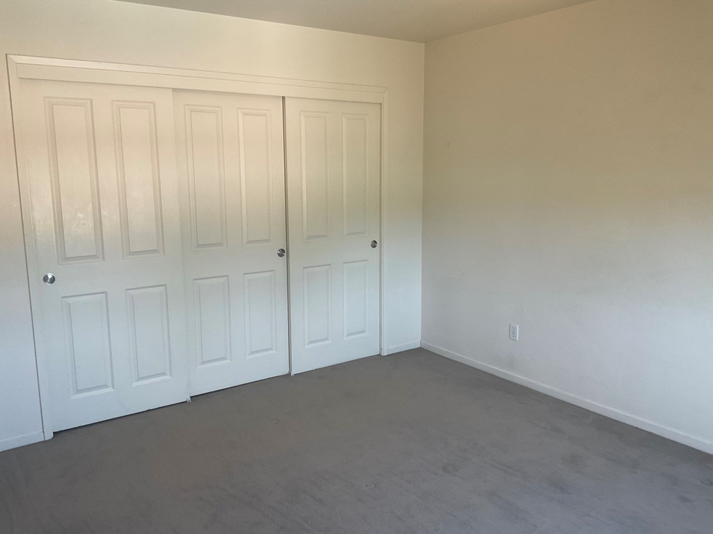a bedroom with two closets and a carpeted floor