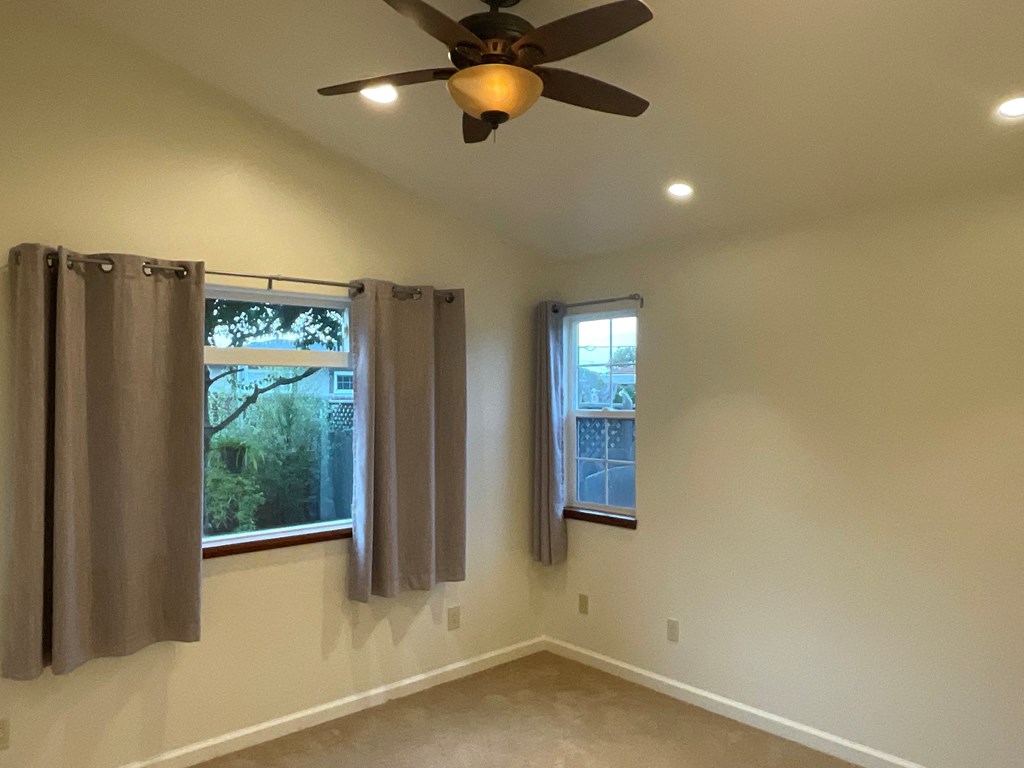 a living room with a ceiling fan and a window