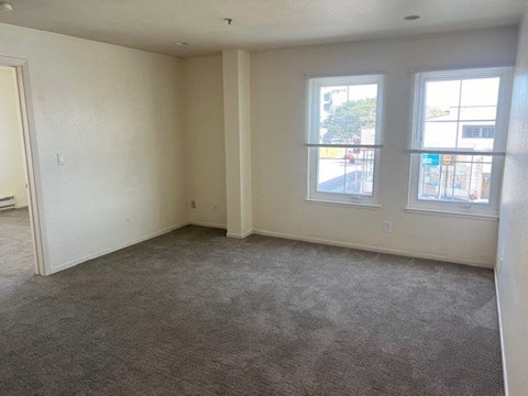an empty living room with two windows