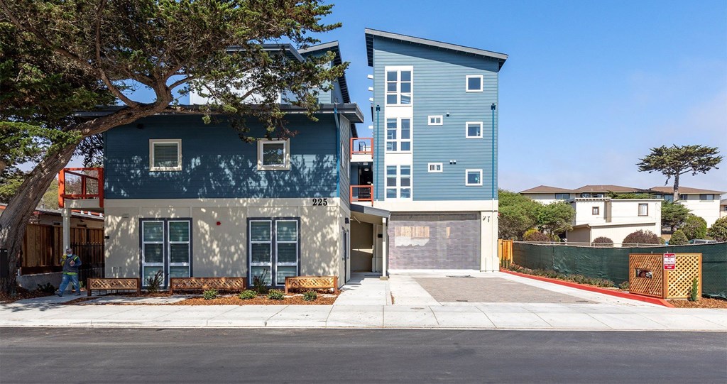 a blue and white house with a tree in front of it