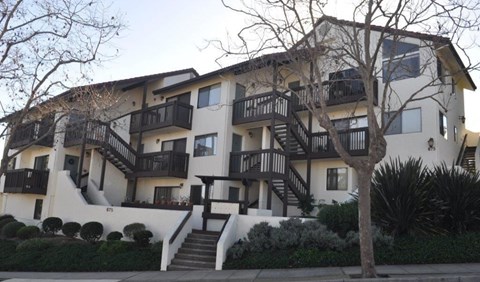 A large white building with black railings and staircases.