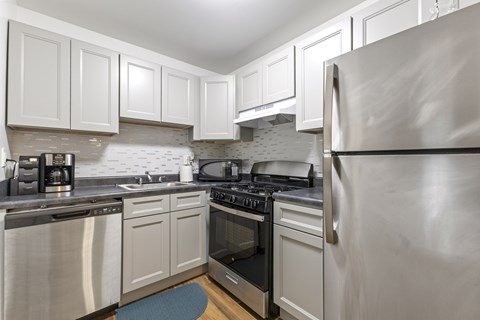 A kitchen with white cabinets and stainless steel appliances.
