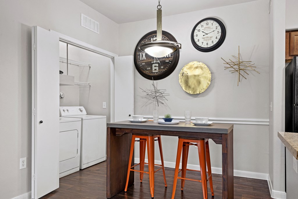 a kitchen with a table and stools and a refrigerator at Bella Madera Apartments, Texas, 75056