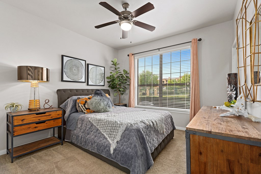 a bedroom with a large window and a ceiling fan at Bella Madera Apartments, Lewisville Texas
