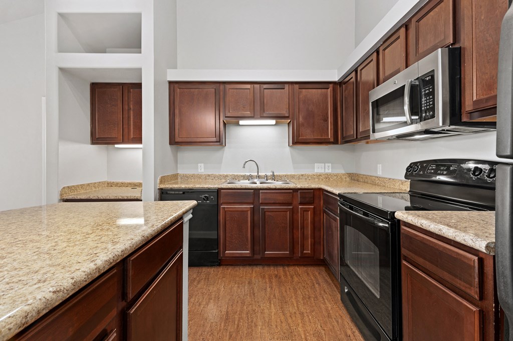 a kitchen with black appliances at Bella Madera Apartments, Lewisville Texas