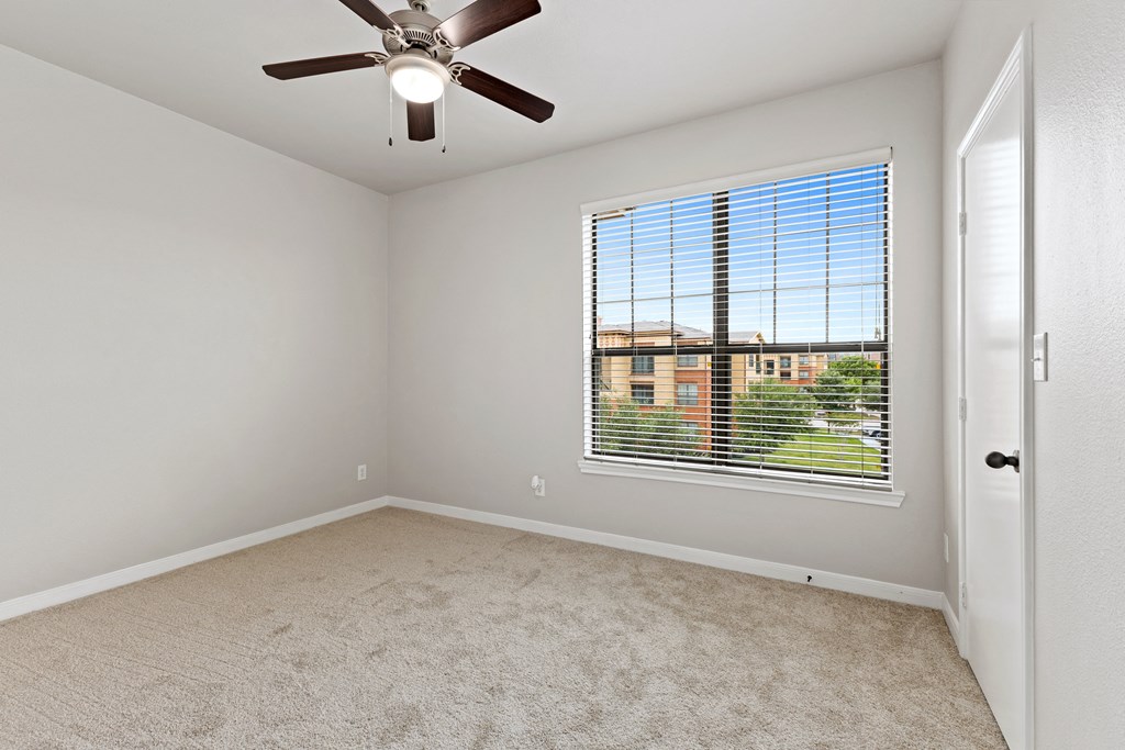 an empty bedroom with a large window and a ceiling fan at Bella Madera Apartments, Lewisville, 75056