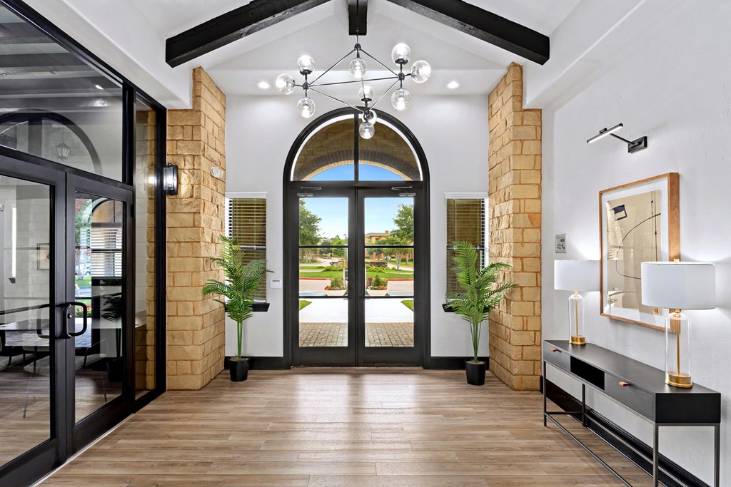a lobby with a large glass door and a chandelier at Bella Madera Apartments, Texas, 75056