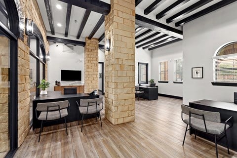 a dining room with a table and chairs and a brick wall