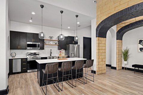 an open kitchen with a large island and black and white cabinets