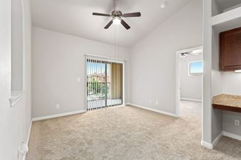 A room with a ceiling fan and carpeted floor.