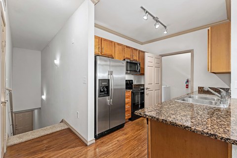 a kitchen with a granite counter top and a stainless steel refrigerator
