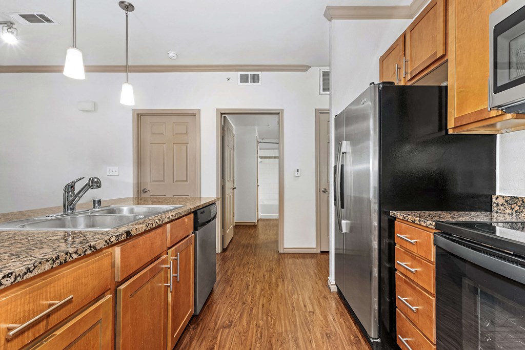 a kitchen with wooden cabinets and a stainless steel refrigerator