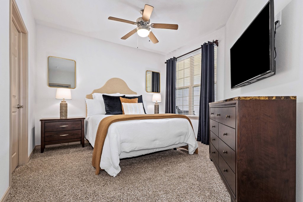 a bedroom with a bed and a ceiling fan