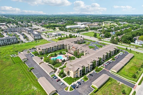A large apartment complex with a pool in the middle of the courtyard.