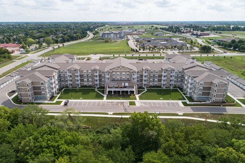 A large apartment complex with a parking lot in front.