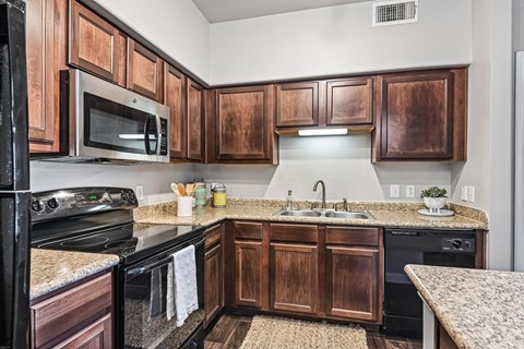 A kitchen with wooden cabinets and black appliances.