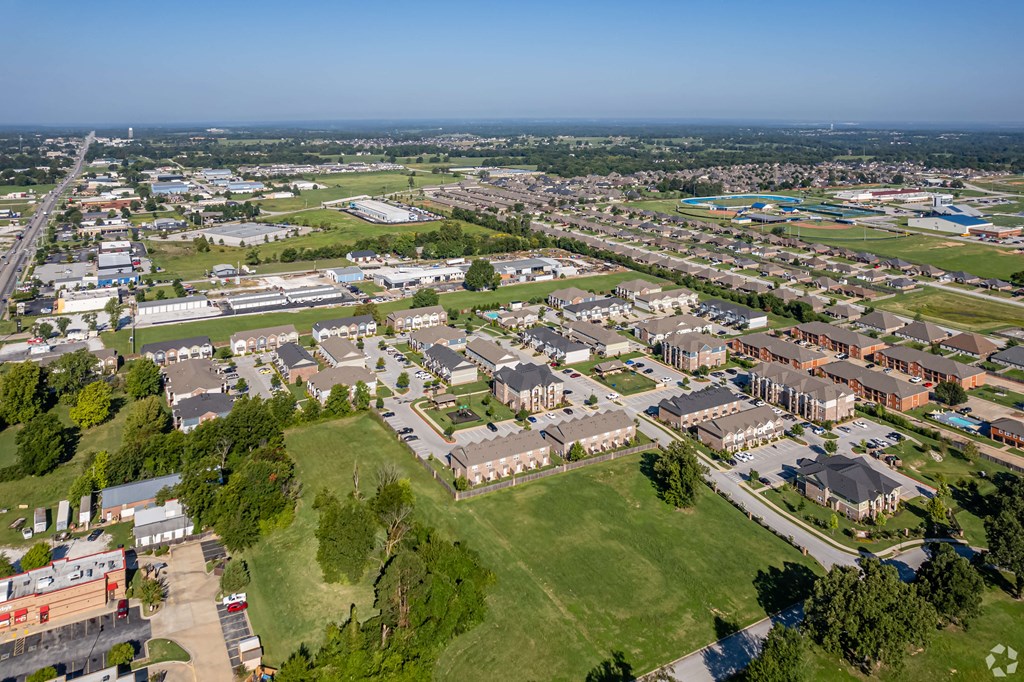 an aerial view of a city with residential buildings and a field