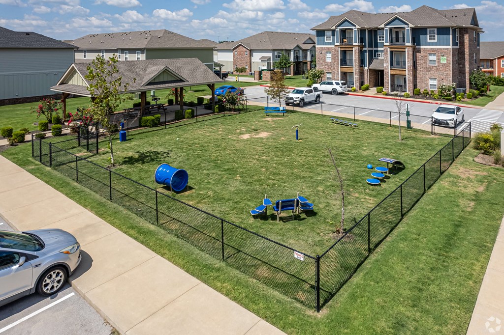 an fenced in yard with playground equipment in front of houses
