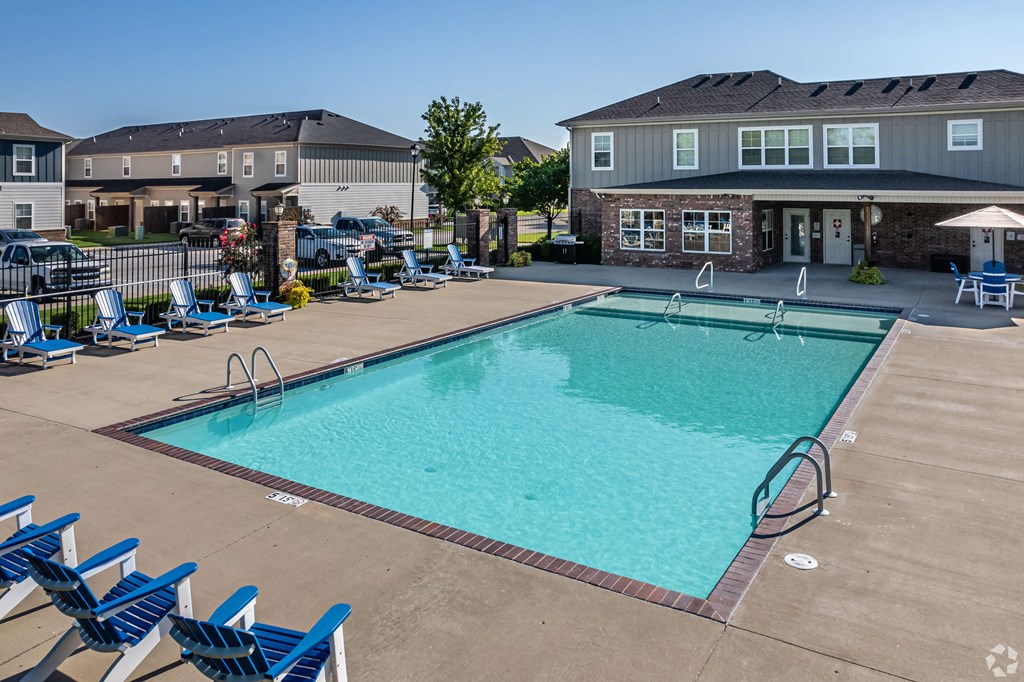 our resort style swimming pool is next to our building and has blue chairs around it