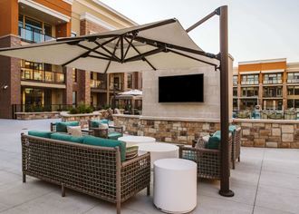 couches under a canapoy at an apartment complex outdoor pool