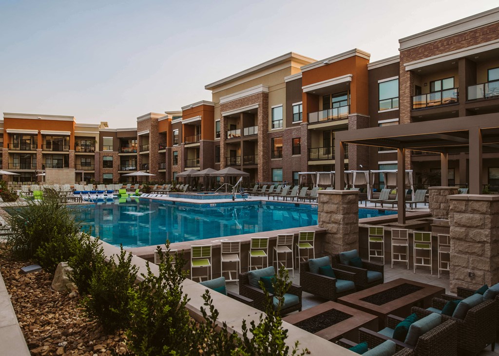 view of outdoor pool and lounge area with chairs surrounded by apartment complex buildings at The Apex at CityPlace, Overland Park, KS, 66210