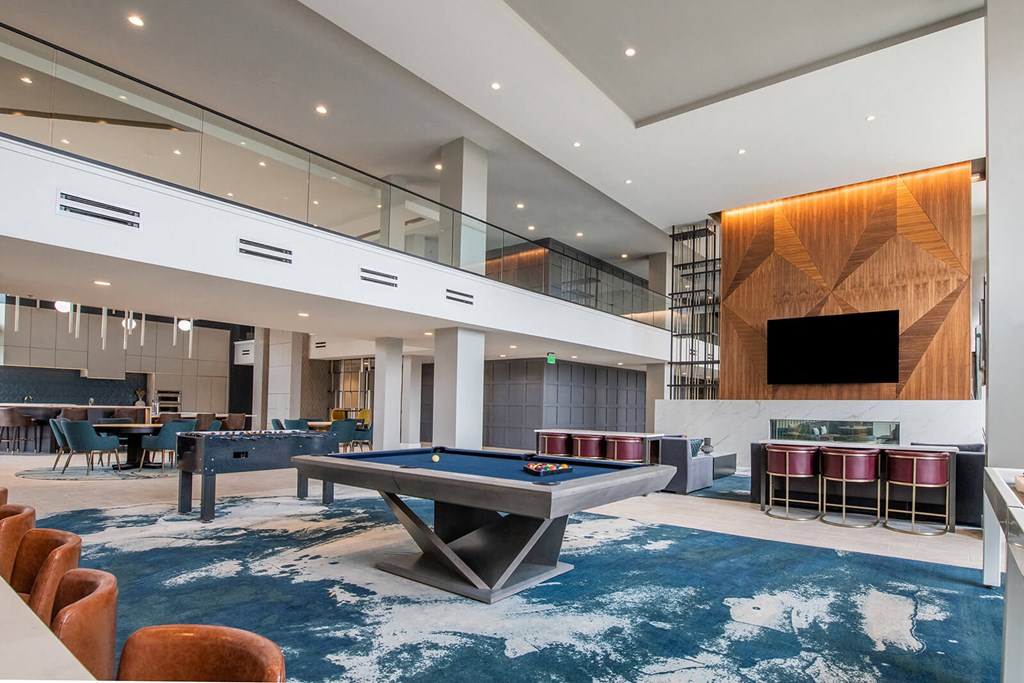 indoor entertainment room with a billiards table, foosball table, and chairs at The Apex at CityPlace, Overland Park, Kansas
