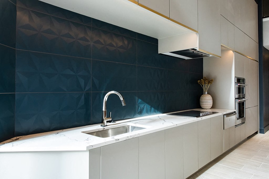 kitchen counter with a sink and stove in white cabinets at The Apex at CityPlace, Kansas, 66210