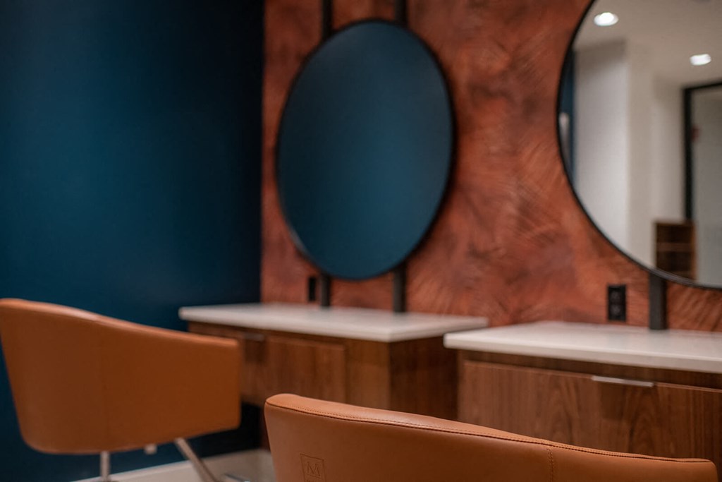 out of focus photo of chairs at desks with circular mirrors on the wall behind them at The Apex at CityPlace, Kansas