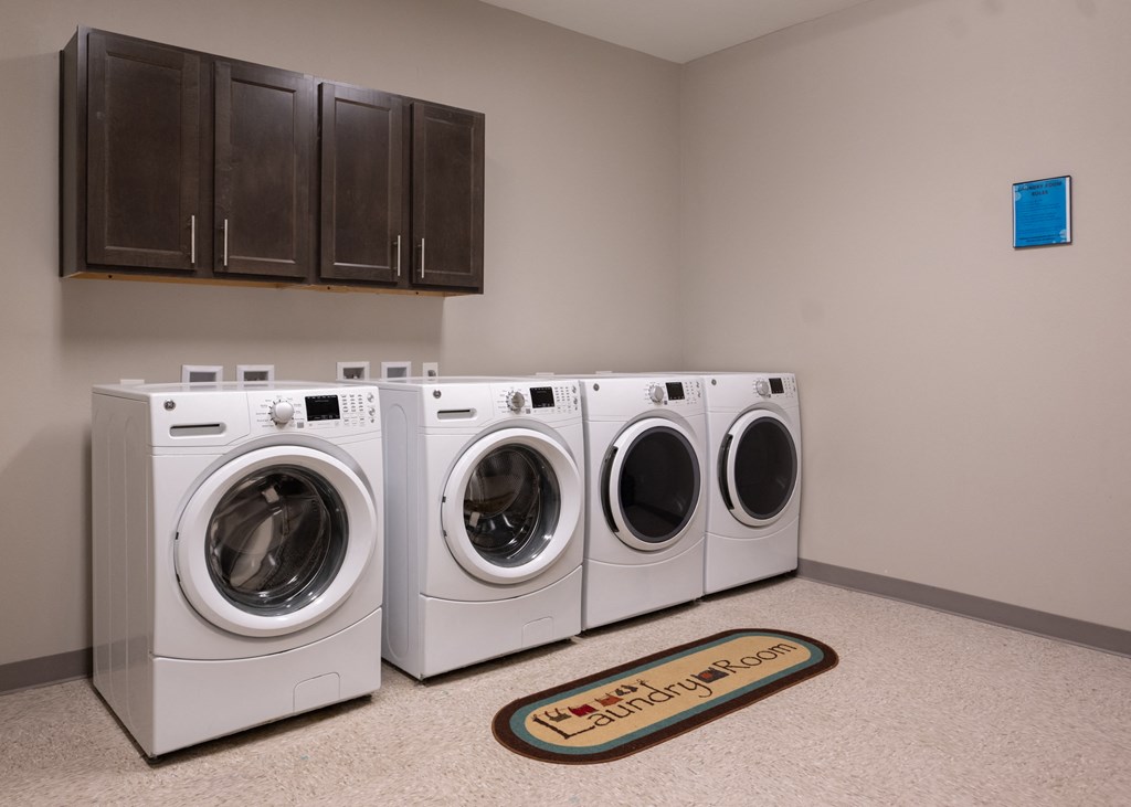 A community laundry room with four machines at Aspen Ridge 55+ Active Adult Community