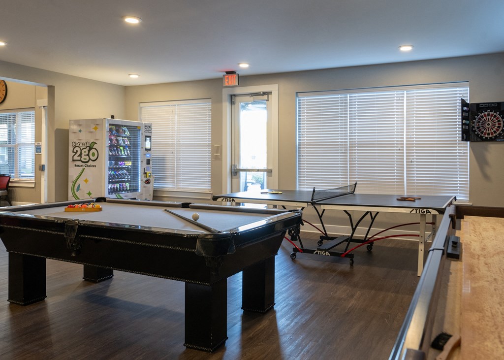 A clubhouse with a pool table and ping pong at Aspen Ridge 55+ Active Adult Community