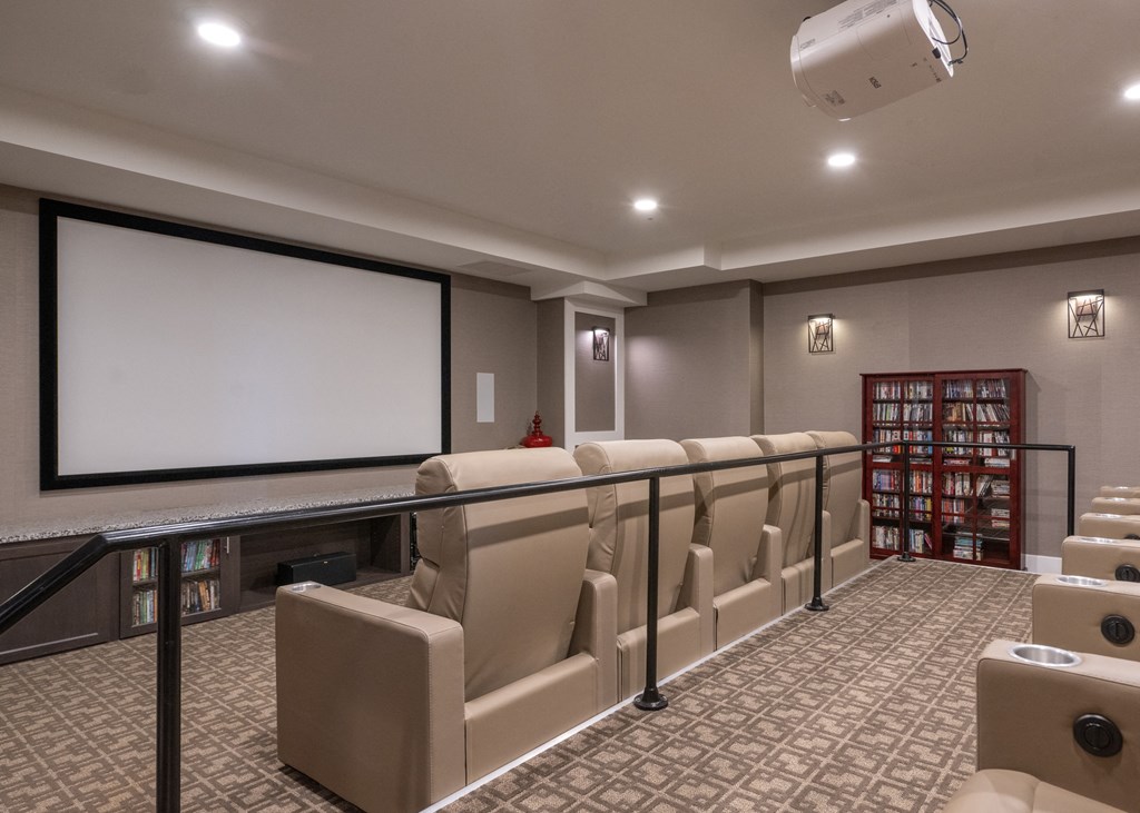 A movie theatre room with chairs and a projector screen at Aspen Ridge 55+ Active Adult Community