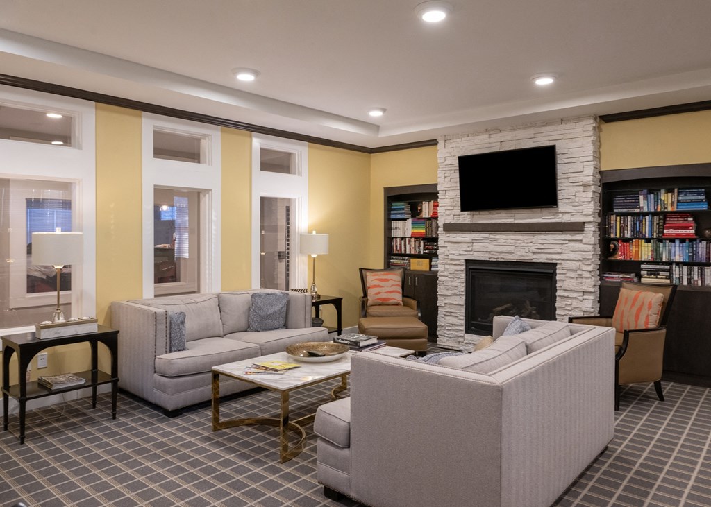 A reading nook with couches and chairs and a fireplace at Aspen Ridge 55+ Active Adult Community