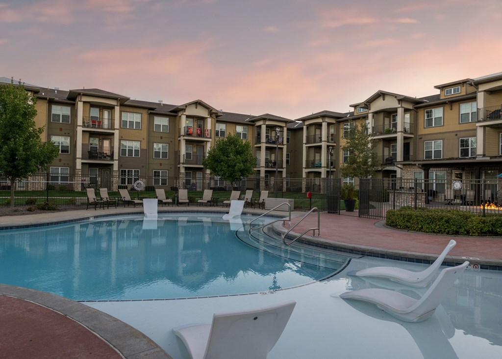 A resort-style swimming pool with lounge chairs at Aspen Ridge 55+ Active Adult Community