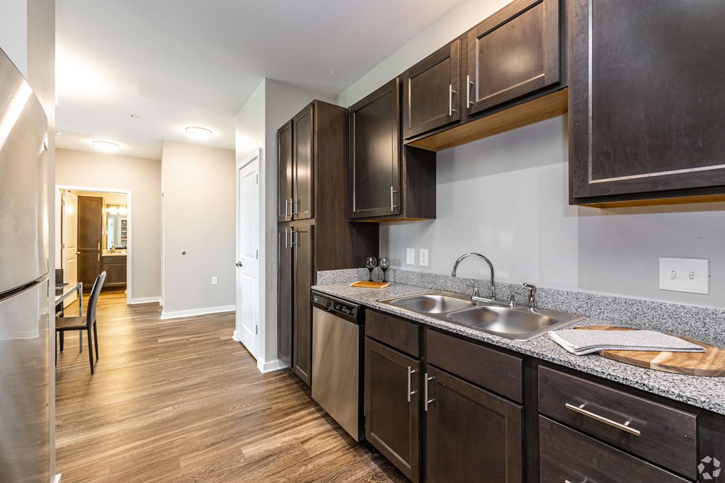 A kitchen with wooden cabinets and a stainless steel sink at Aspen Ridge 55+ Active Adult Community