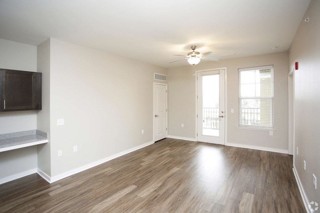 An empty living room with wood floors and a ceiling fan at Aspen Ridge 55+ Active Adult Community