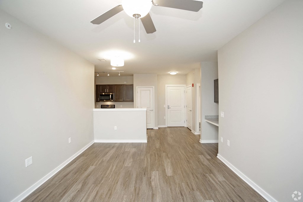An empty living room and kitchen with a ceiling fan at Aspen Ridge 55+ Active Adult Community