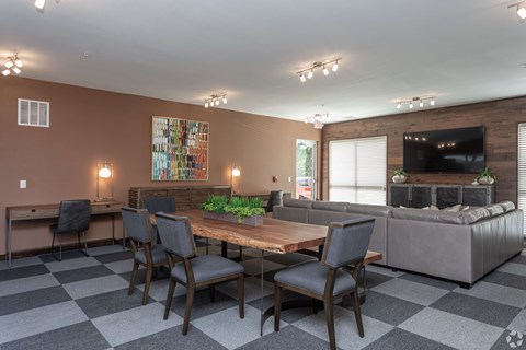 A modern living room with a checkered floor and a large painting on the wall.