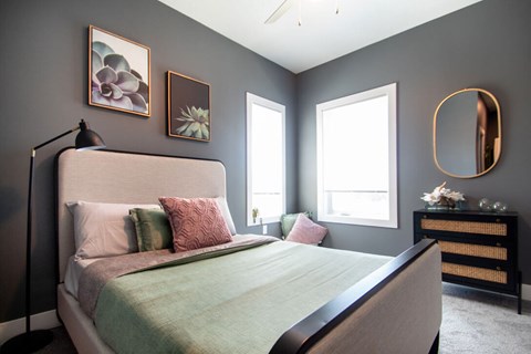 A bedroom with a large bed and a mirror on the wall.