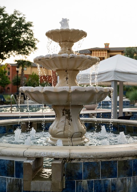 A white fountain with water spraying out of it.