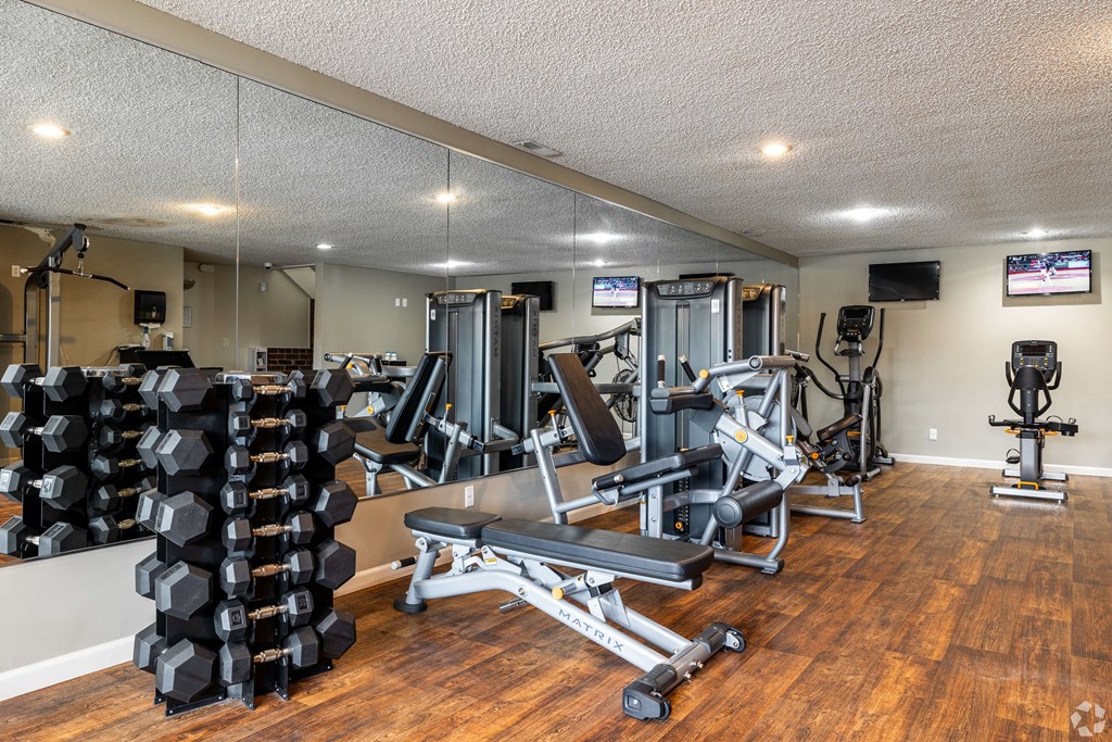 A gym with a variety of equipment including weights and machines.