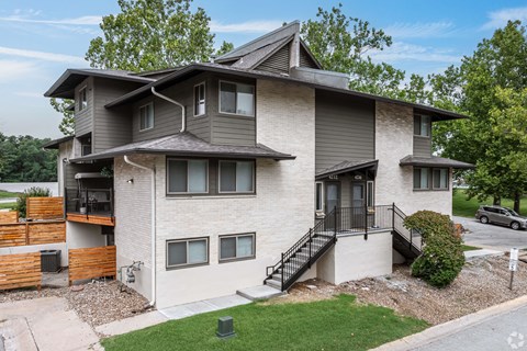 A modern two-story house with a balcony on the second floor.